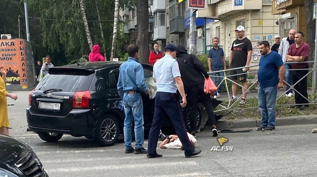 Водитель лежал на асфальте: Toyota столкнулась с машиной ДПС в Новосибирске. ФОТО